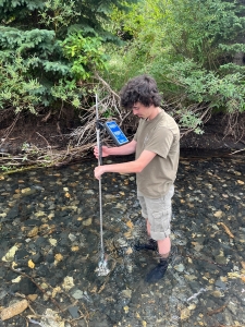 student taking water sample data in a colorado river