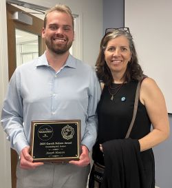 Joe Hansen holds his plaque while standing next to mentor Dr. Ruth H. Carmichael
