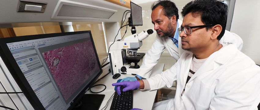 Two MCI researchers working on a computer.