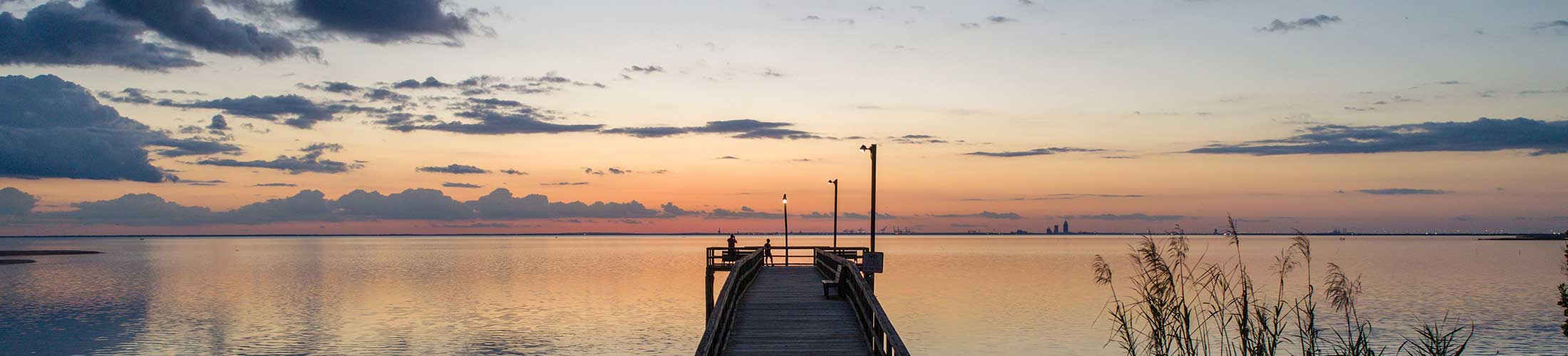 Fairhope pier over the water with the sun setting.