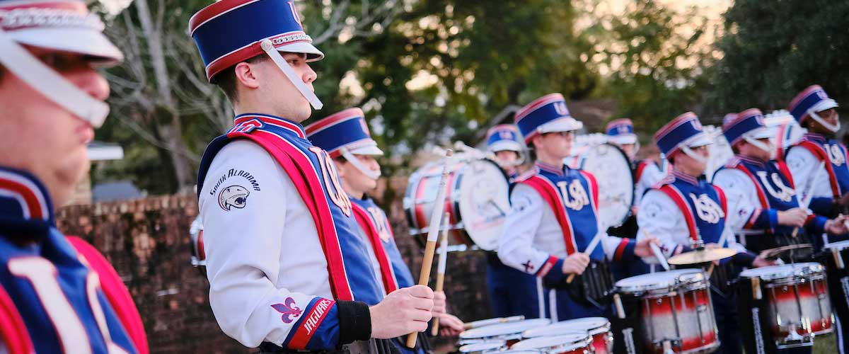 Drumline warming up in uniform.